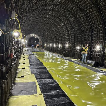 Los equipos instalan una capa impermeable amarilla a lo largo del fondo del nuevo túnel de salida en la presa Anderson en Morgan Hill.