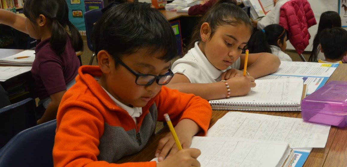 Children writing in a classroom