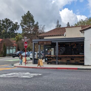 La esquina de una calle de la ciudad con un café llamado Café Dio