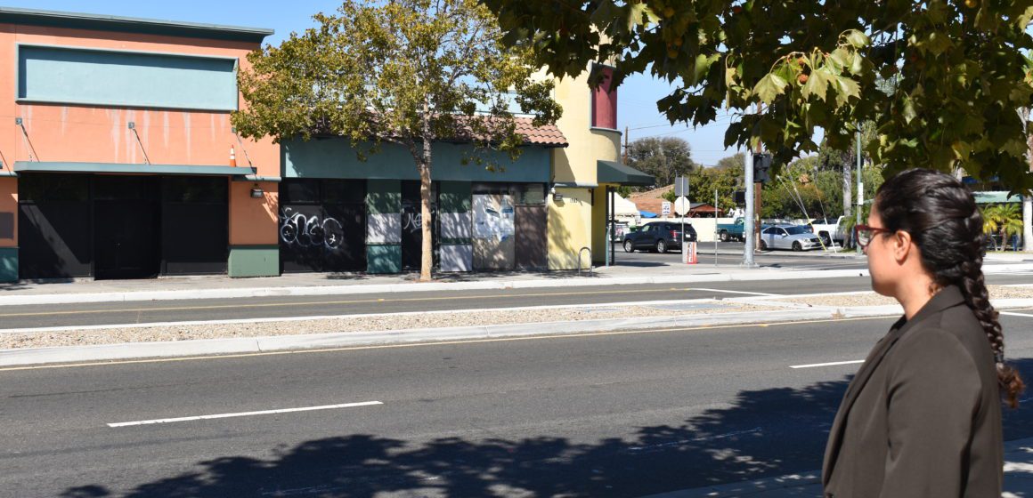 A woman standing outside looking at buildings across the street