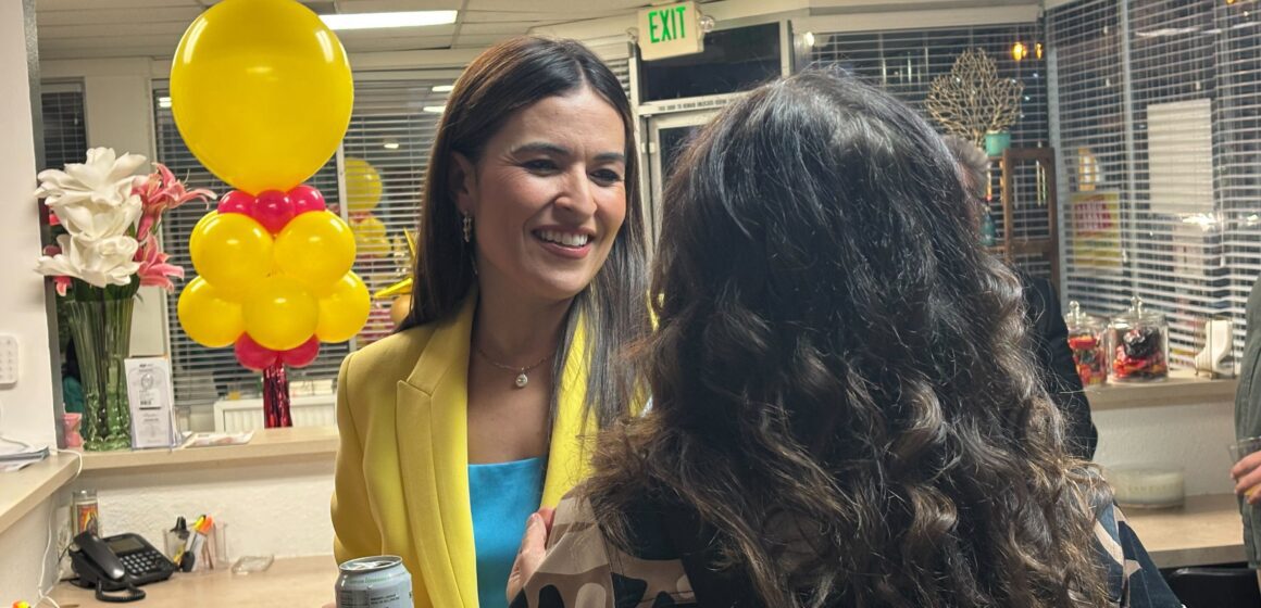 A woman smiling while talking to another woman