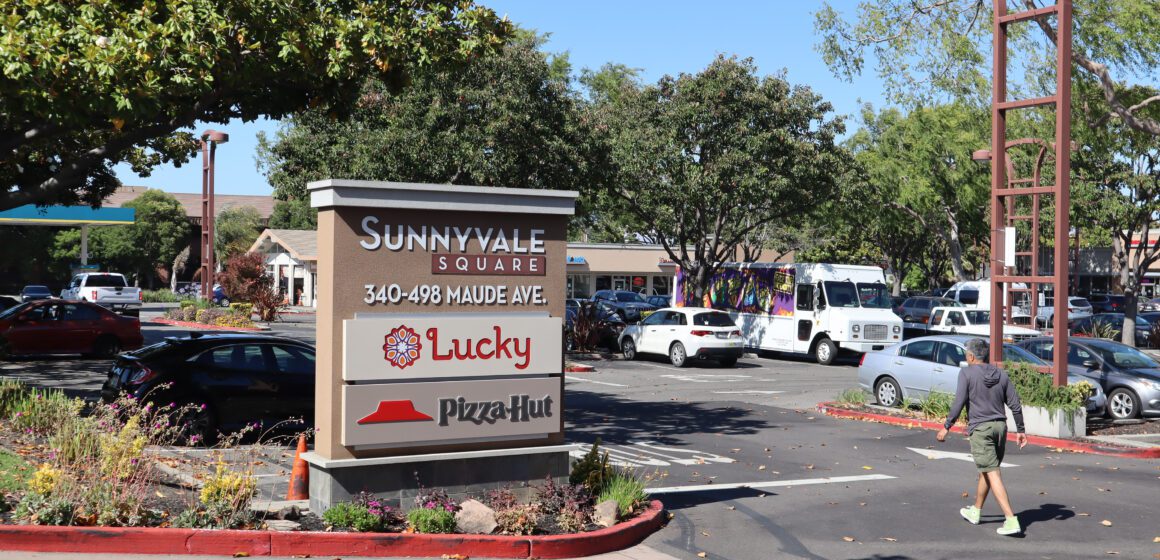 Foto de un estacionamiento y un cartel que muestra la dirección de Sunnyvale Square, 340-498 Maude Ave, donde hay un Lucky Supermarket y Pizza Hut.