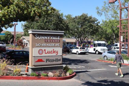 Foto de un estacionamiento y un cartel que muestra la dirección de Sunnyvale Square, 340-498 Maude Ave, donde hay un Lucky Supermarket y Pizza Hut.