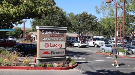 Ảnh bãi đậu xe và biển báo hiển thị địa chỉ của Sunnyvale Square, 340-498 Maude Ave, nơi có Siêu thị Lucky và Pizza Hut