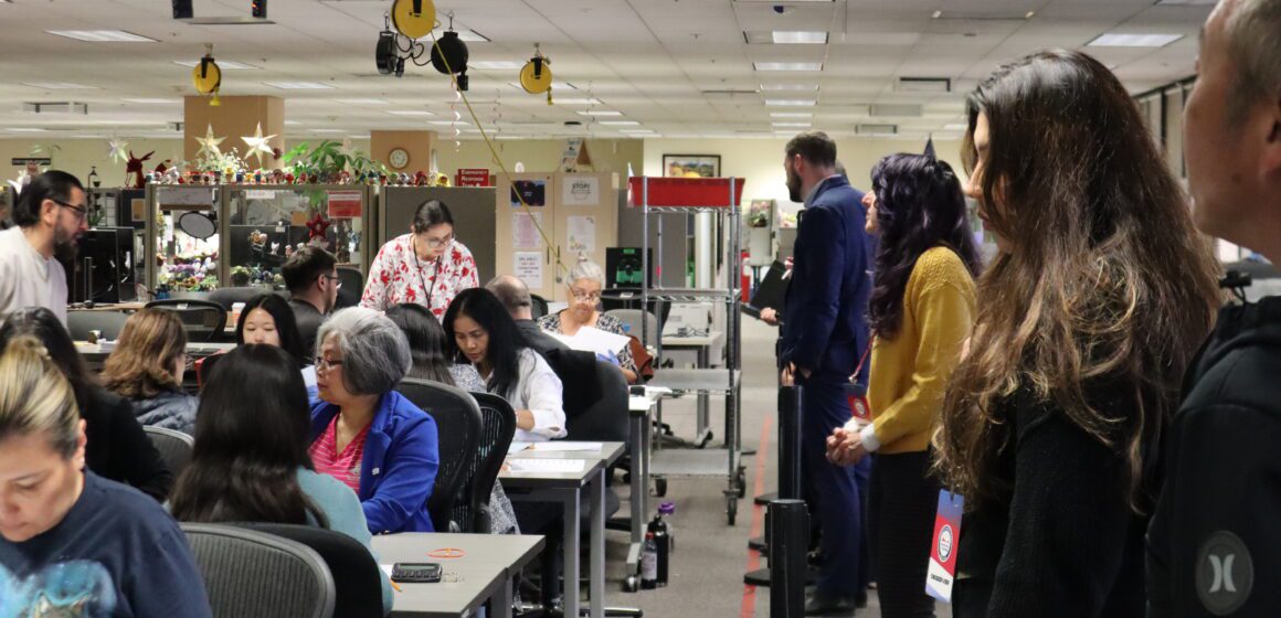 Election observers watch workers manually count voter ballots