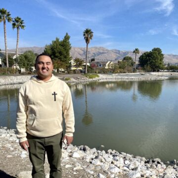 El ex alcalde de Milpitas, Rich Tran, de pie frente a un pequeño lago con las colinas de Milpitas al fondo