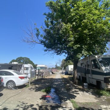 Una casa rodante y autos estacionados en un parque en San José