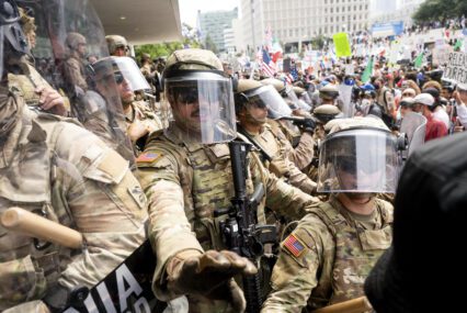 A group of National Guard members and Marines holding back demonstrators