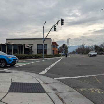 An intersection along Bollinger Road in Cupertino with cars and a stoplight.