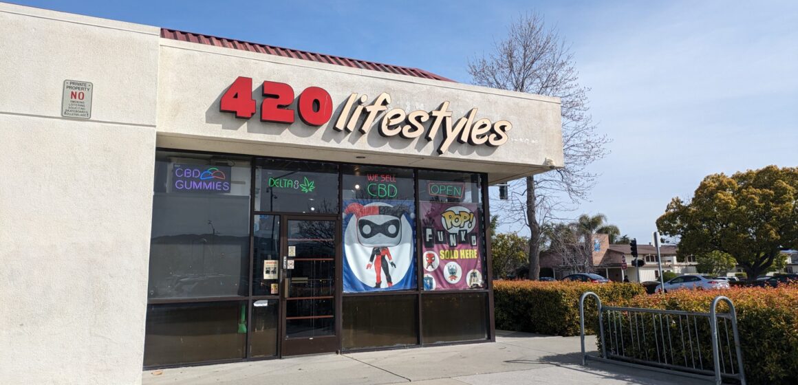 The outside of a smoke shop, with signs that read 420 Lifestyles, We sell CBD and CBD gummies